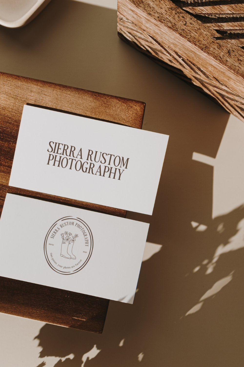 A laptop displaying a wedding photography website is placed on an outdoor floral table setting with flowers and candles in the background. | Converting Website Visitors to Leads